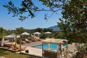 a resort with a pool and lounge chairs and a swimming pool at Villa Les Bergeries De Calvi in Calvi