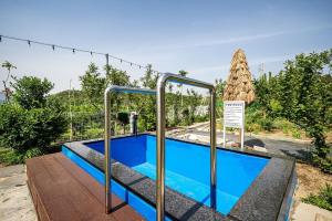 a swimming pool at a resort with a sign next to it at Cheongdo Peach Blossom Private Pension in Sora