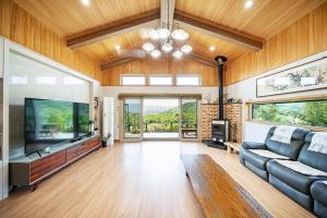 a living room with a couch and a flat screen tv at Cheongdo Peach Blossom Private Pension in Sora