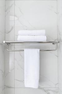 una pila de toallas en un toallero en el baño en Illovo Hotel, en Johannesburgo