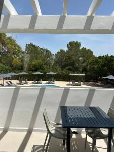 a patio with a table and chairs and a pool at Serena Sol Apartments - Adults Only - Over 12 in Cala Serena