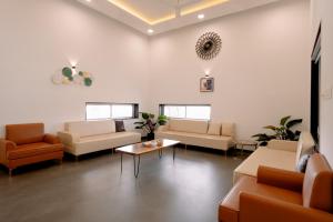 ナーシクにあるStayVista's Eva Villa - Lakeside Luxury with Modern Decor, Pool & Expansive Lawn - Near Sulaのソファとテーブルが備わる待合室