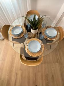 een glazen tafel met borden en glazen erop bij Apartamento Carmen Centro in Nerja