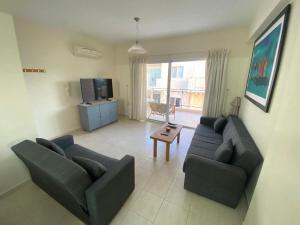 a living room with two couches and a television at Poolside Escape - Polis in Polis Chrysochous