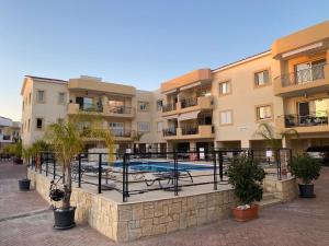 an apartment complex with a swimming pool in a courtyard at Poolside Escape - Polis in Polis Chrysochous