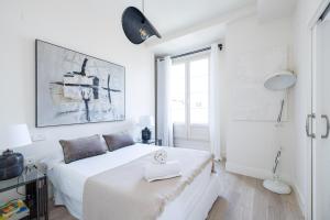 a white bedroom with a bed and a window at Granada Luxury Apartments in Granada