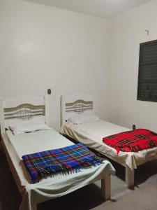 Dos camas una al lado de la otra en una habitación. en Recanto dos Amigos, en Tietê
