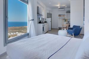 a bedroom with a white bed and a large window at SantoView Villas in Vourvoúlos