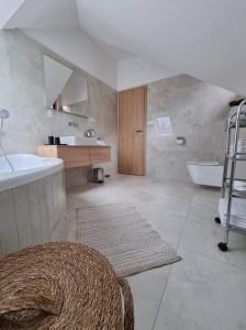 a bathroom with a tub and a sink and a bath tub at Apartmán Na Břehu in Luhačovice