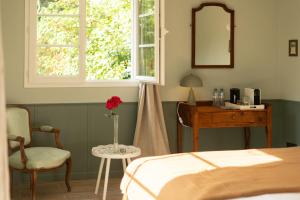 a bedroom with a bed and a table and a mirror at Le Clos du Château in Amboise