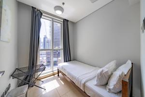 a bedroom with a bed and a large window at 1BR + maid room Apartment in Downtown Dubai in Dubai +29 photos