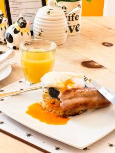 a plate with a piece of dessert and a glass of orange juice at The Hive at 52 in Northwich