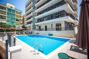 a swimming pool in front of a building at Adriatic Residence in Budva
