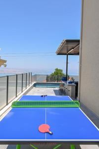two ping pong tables on a balcony with the ocean at חופש יהונתן-וילה חלמונית יוקרתית עם נוף לכנרת Hofesh Yehonatan Villa in Tiberias +96 photos