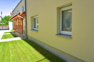two windows on the side of a building with grass at Ferienwohnung Sonnenschein in Jüterbog