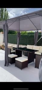 a patio with tables and chairs under an umbrella at La casita de lola in Sotillo de la Adrada
