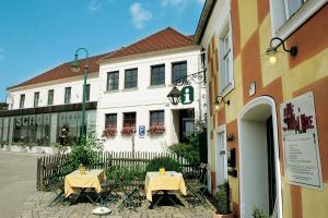 ein Gebäude mit zwei Tischen davor in der Unterkunft Hotel Zur Schonenburg in Schönberg am Kamp