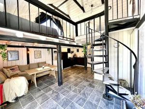 a living room with a couch and a staircase in a building at Charming 5 bed studio at Getterön in Varberg