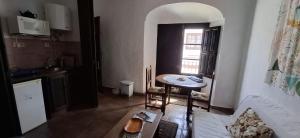 a room with a table and a kitchen with a window at Casa Rural El Antiguo Juzgado in Jimena de la Frontera