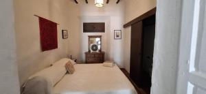 a bedroom with a bed and a dresser in it at Casa Rural El Antiguo Juzgado in Jimena de la Frontera