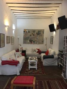 a living room with couches and a table at Casa Rural El Antiguo Juzgado in Jimena de la Frontera