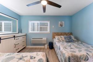 Un dormitorio con dos camas y un ventilador de techo. en 301 Ocean Ave, Unit 101 - The Harbor Light, en North Wildwood