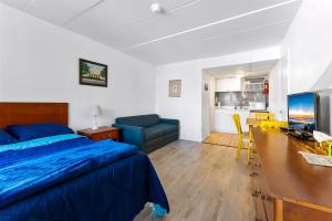 a bedroom with a bed and a desk and a couch at 313 E Glenwood Ave, Unit 109 in Wildwood