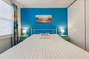 a bedroom with a white bed with a blue wall at 307 E Crocus Rd, Unit B in Wildwood Crest