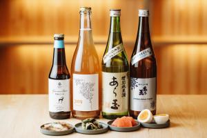 a group of three bottles of wine sitting on a table at Bed and Vegetable Kahoku 