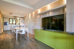 une cuisine avec une table à manger et une télévision grand écran dans l'établissement Villetta dei Pascoli, à Baveno