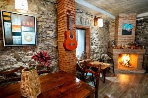 a living room with a guitar hanging on a brick wall at Shale Tsagveri in Tsaghveri