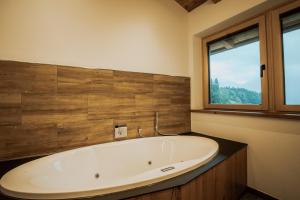 un bagno con ampia vasca e finestra di Rufana Alpin a Bürserberg