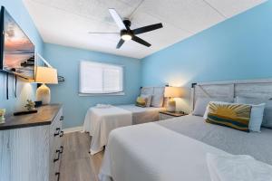 a bedroom with two beds and a ceiling fan at 301 Ocean Ave, Unit 316 - The Harbor Light in North Wildwood +12 photos