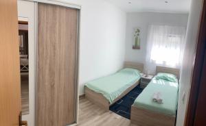 mały pokój z 2 łóżkami i lustrem w obiekcie Apartman Turanj w mieście Turanj