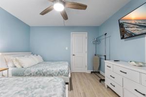 a bedroom with two beds and a ceiling fan at 301 Ocean Ave, Unit 110 - The Harbor Light in North Wildwood +13 photos