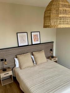 a bedroom with a large bed with a wicker headboard at Sabl'Appart Gare in Les Sables-d'Olonne