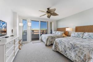 a bedroom with two beds and a ceiling fan at Residence 404 At The Grand in Wildwood
