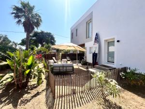 una cerca con un paraguas al lado de una casa en Bas de villa la sablhyeres- 300m Plage de la Capte - 2 hébergements disponibles, en Hyères