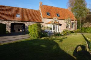 een groot bakstenen huis met een oranje dak bij Jardin de Lieze in Maldegem