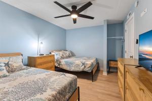 Un dormitorio con dos camas y un ventilador de techo. en 301 Ocean Ave, Unit 217 - The Harbor Light, en North Wildwood