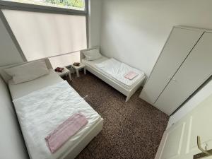 twee bedden in een kleine kamer met een raam bij Unterkunft 20 Eibach in Neurenberg +2 foto's