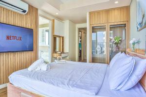 a bedroom with a large bed and a tv at SeaSky View Suites - Gold Coast Tower, Nha Trang Beach & Lotte Mall in Nha Trang