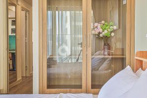 a bedroom with a glass door with a vase of flowers at SeaSky View Suites - Gold Coast Tower, Nha Trang Beach & Lotte Mall in Nha Trang +16 photos
