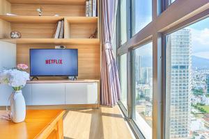 a living room with a tv and a large window at SeaSky View Suites - Gold Coast Tower, Nha Trang Beach & Lotte Mall in Nha Trang