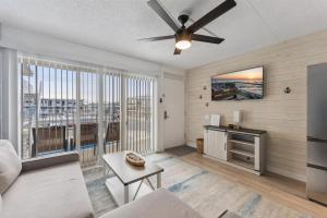 a living room with a ceiling fan and a large window at 301 Ocean Ave, Unit 204 - The Harbor Light in North Wildwood
