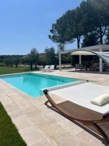 a swimming pool with a chaise lounger next to at Villa Laura in Neviano
