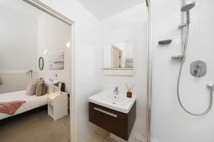 a white bathroom with a sink and a shower at Modern 3BR - Flat Sleeps 8 - Walk to Liverpool St in London