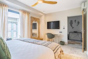 a bedroom with a bed with a ceiling fan at VILLA EDEN PALM - Luxe et sérénité in Petite Île