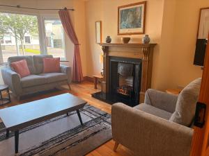 ケンメアにあるConvenient spacious 3 bedroom home in Kenmare townのリビングルーム(暖炉、ソファ、テーブル付)