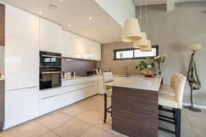 a kitchen with white cabinets and a large island at House 5p with garden in the heart of Saint-Raphaël in Saint-Raphaël